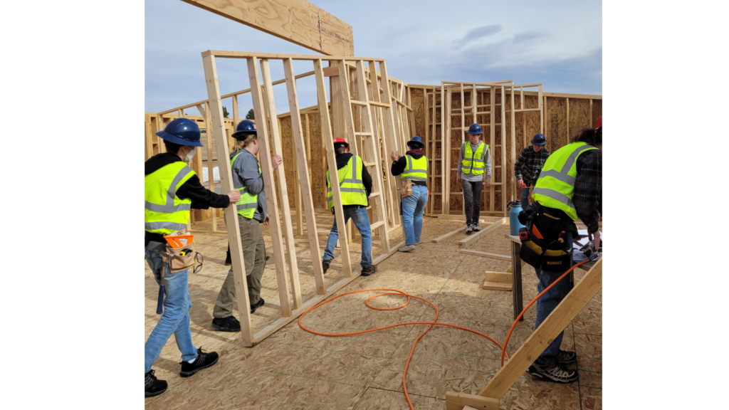 A group of students building the frame of a house