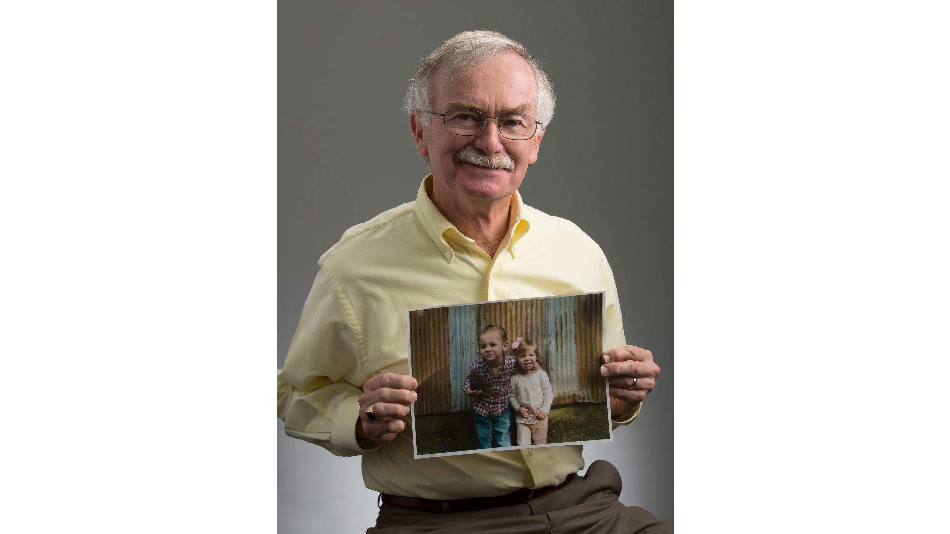 Man holding a picture of two children